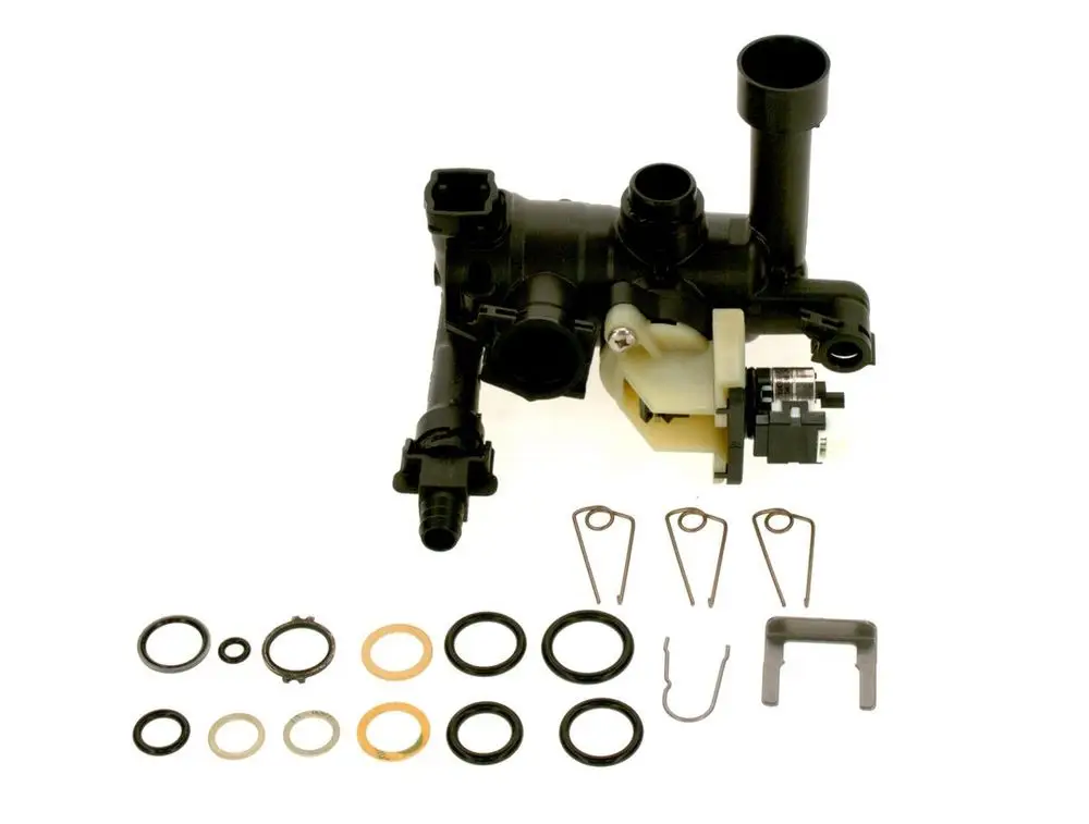 BOSCH Rücklaufeinheit mit zugehörigen Dichtungen und Clips, auf einem weißen Hintergrund abgebildet. Die Einheit ist aus Kunststoff mit mehreren Anschlussöffnungen.